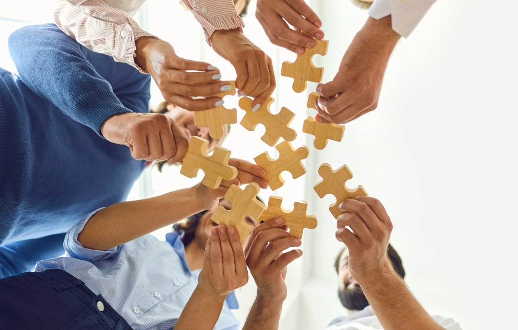 People holding puzzle pieces together