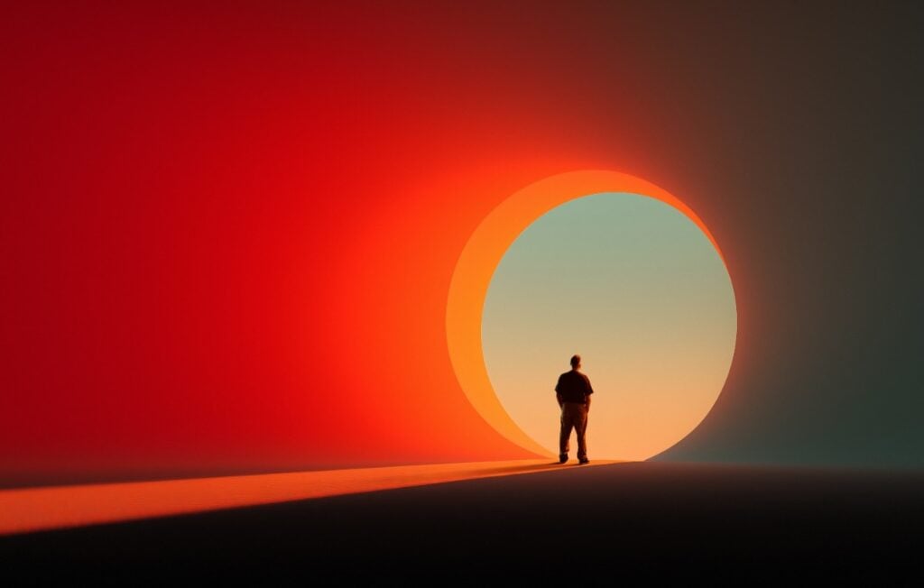 Man facing circular glowing entrance in colorful scene.