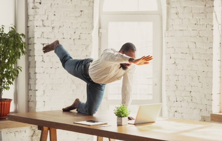 man doing yoga at home while being quarantine and freelance online working.