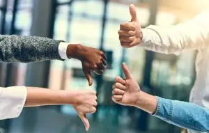 Business people with thumbs up and down