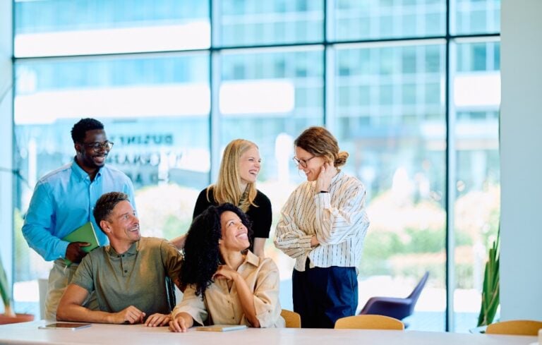 Group of happy multiracial business people discussing work during a meeting, showing teamwork and positive corporate culture
