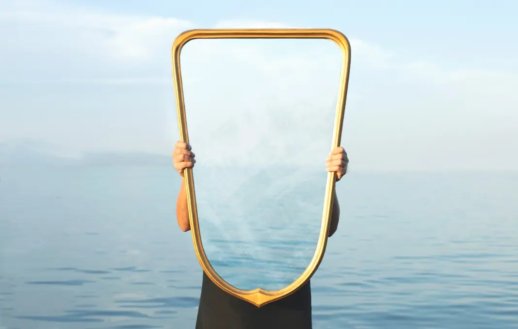 Person standing behind transparent mirror