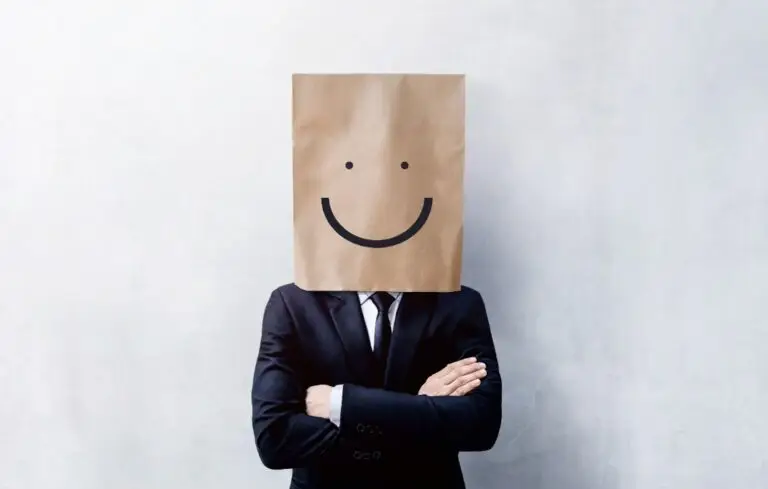 Businessman with paperbag with smiley face drawn on over head